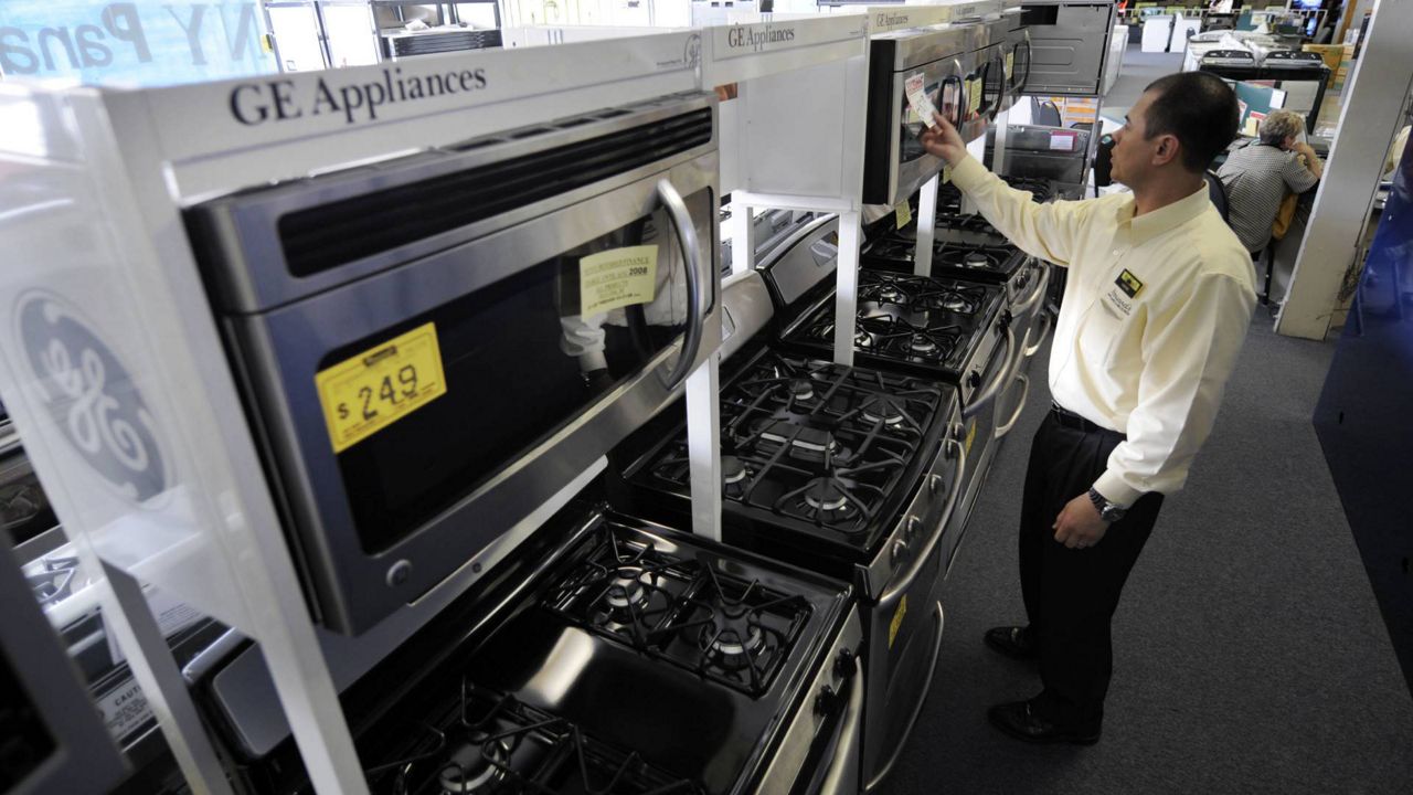 In this April 8, 2008 file photo, salesman Hank Pham puts the price on a General Electric microwave oven in the appliances section of Howard's Appliance and Big-Screen Superstore in San Gabriel, Calif. (AP Photo/Kevork Djansezian)