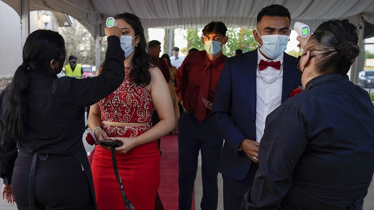 Grace Gardens Event Center employees check temperatures of young people attending prom at the Grace Gardens Event Center in El Paso, Texas on Friday, May 7, 2021. (AP Photo/Paul Ratje)