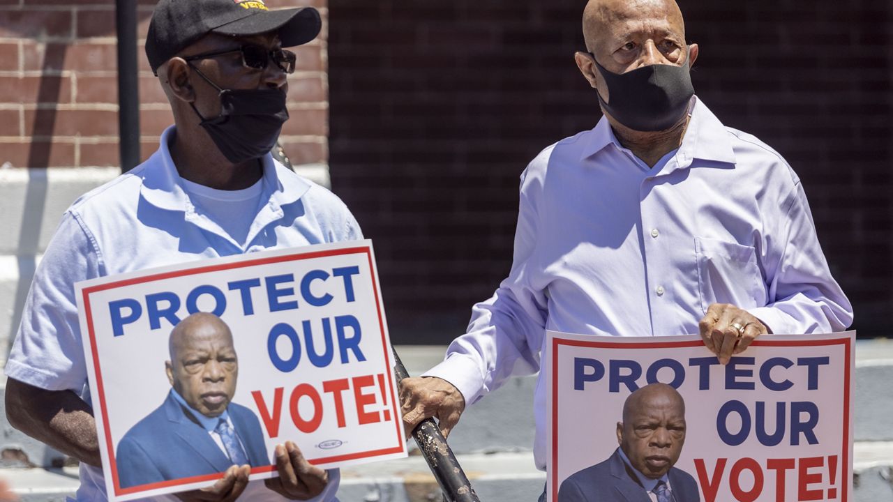 Henry Allen, left, and Charles Mauldin stand for the protection of voting rights at the John Lewis Advancement Act Day of Action, a voter education and engagement event taking place at Brown Chapel A.M.E. Church, Saturday, May 8, 2021, in Selma, Ala. Both men participated in the 1964 - 1965 Selma civil rights movement. (AP Photo/Vasha Hunt)