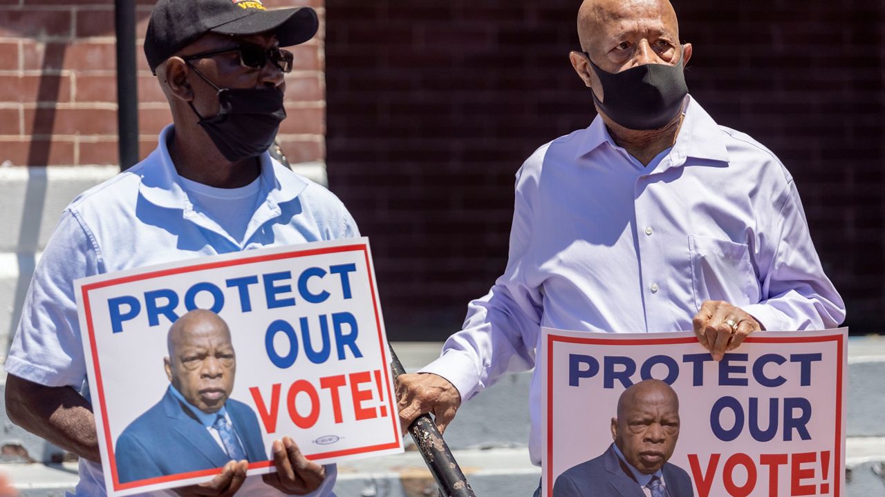 Henry Allen, left, and Charles Mauldin stand for the protection of voting rights at the John Lewis Advancement Act Day of Action, a voter education and engagement event taking place at Brown Chapel A.M.E. Church, Saturday, May 8, 2021, in Selma, Ala. (AP Photo/Vasha Hunt)