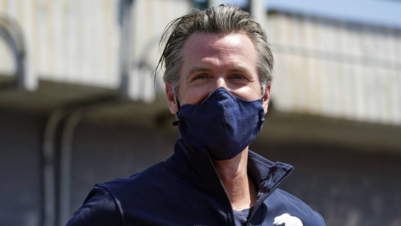 California Gov. Gavin Newsom smiles as he readies to hold a news conference Tuesday, May 11, 2021, in Los Angeles. (AP Photo/Marcio Jose Sanchez)