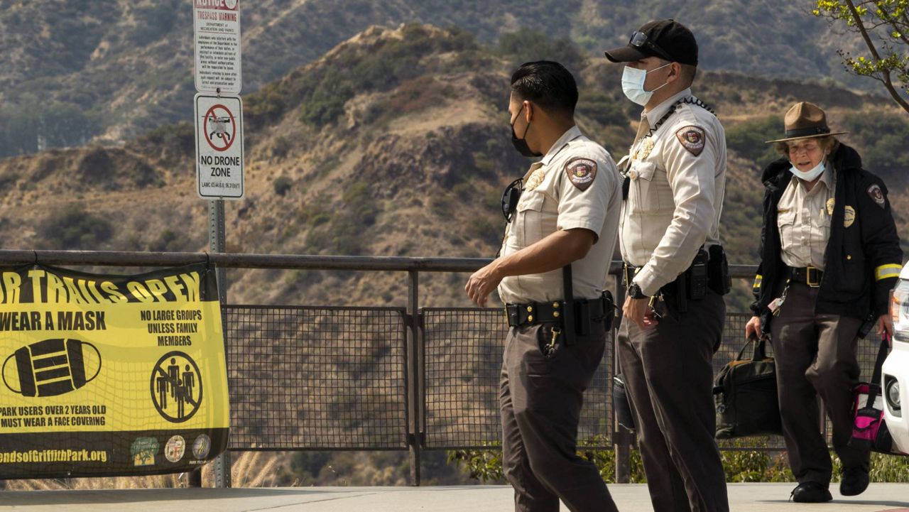 Los Angeles Park Rangers wear face masks at the Griffith Observatory in Los Angeles, May. 17, 2021. (AP Photo/Damian Dovarganes)