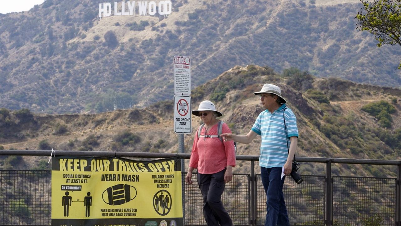 Visitors are seen without face masks at the Griffith Observatory in Los Angeles, Monday, May 17, 2021. (AP Photo/Damian Dovarganes)