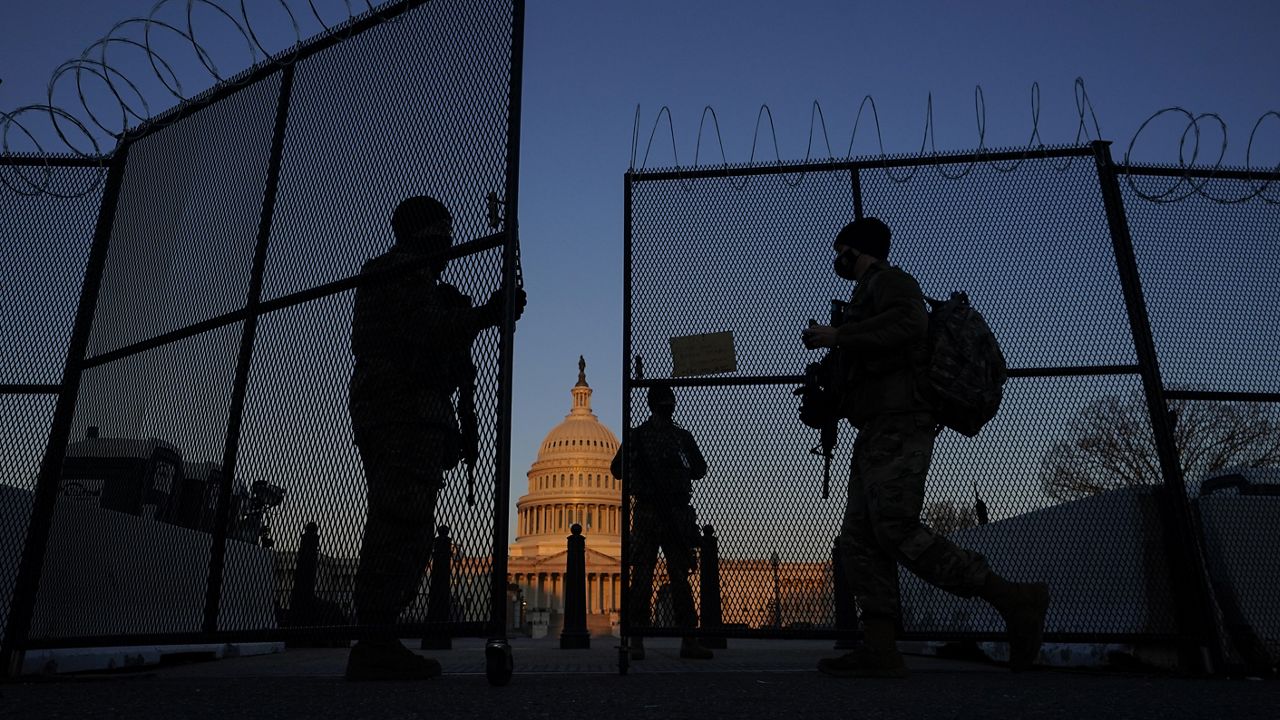 FILE - In this March 8, 2021, file photo, members of the National Guard open a gate in the razor wire topped perimeter fence around the Capitol at sunrise in Washington. (AP Photo/Carolyn Kaster, File)