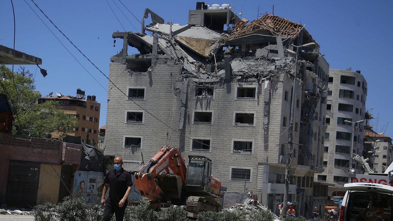 A Palestinian walks by a building hit by an Israeli airstrike in Gaza City, Tuesday, May 18, 2021. (AP Photo/Hatem Moussa)