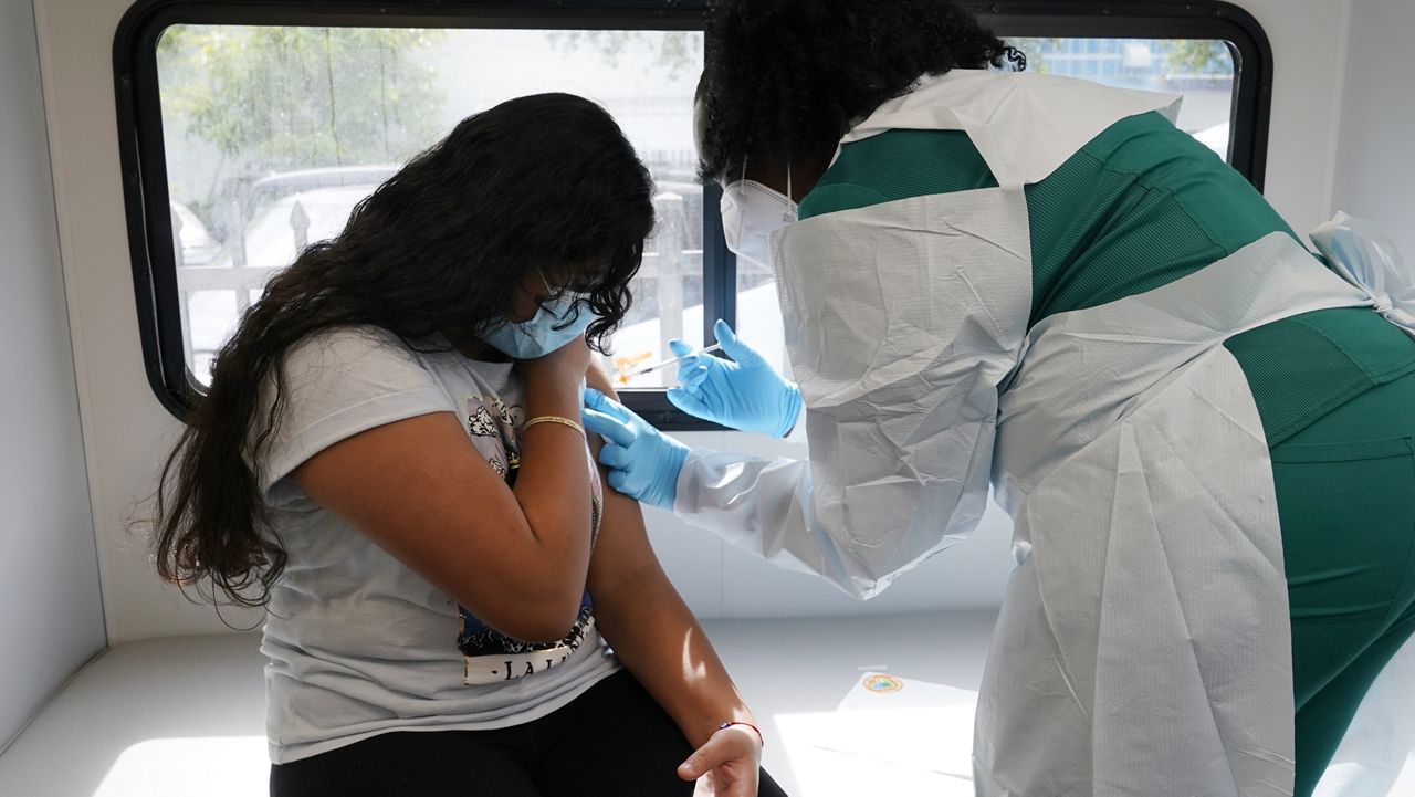 Jenna Ramkhelawan, 12, receives the first dose of the Pfizer Covid-19 vaccine from LPN nurse Dolores Fye, Tuesday, May 18, 2021, in Miami. (AP Photo/Marta Lavandier)