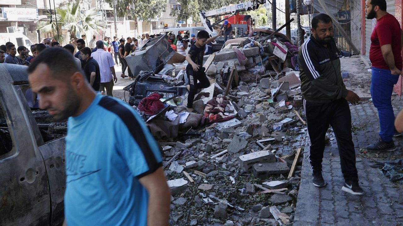 People inspect the rubble of destroyed the Abu Hussein building that was hit by an Israeli airstrike early Wednesday morning Gaza City. (AP Photo/Adel Hana)