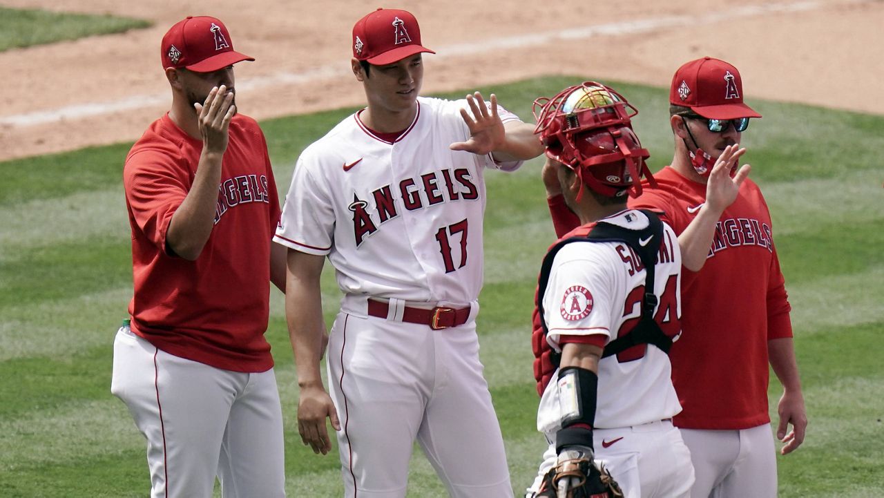 Los Angeles Angels' Shohei Ohtani, second from left, of Japan, high fives catcher Kurt Suzuki while celebrating the team's 7-1 win against the Minnesota Twins in the first baseball game of a doubleheader, Thursday, May 20, 2021, in Anaheim, Calif. (AP Photo/Jae C. Hong)
