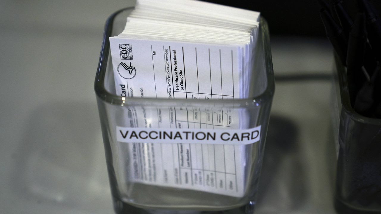 COVID-19 vaccination cards are displayed on a check-in table at Providence Edwards Lifesciences vaccination site in Santa Ana, Calif., Friday, May 21, 2021. (AP Photo/Jae C. Hong)