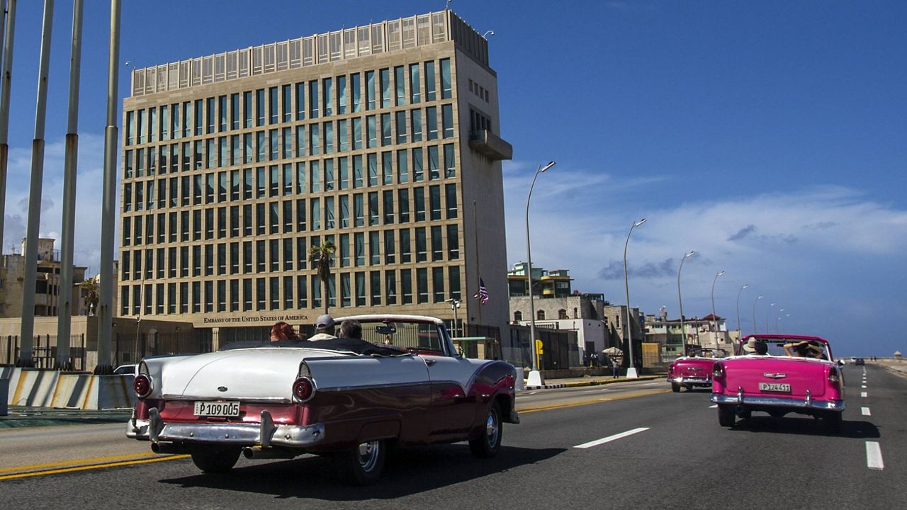 Tourists ride classic convertible cars on the Malecon beside the United States Embassy in Havana, Cuba, on Oct. 3, 2017. (AP Photo/Desmond Boylan, File)