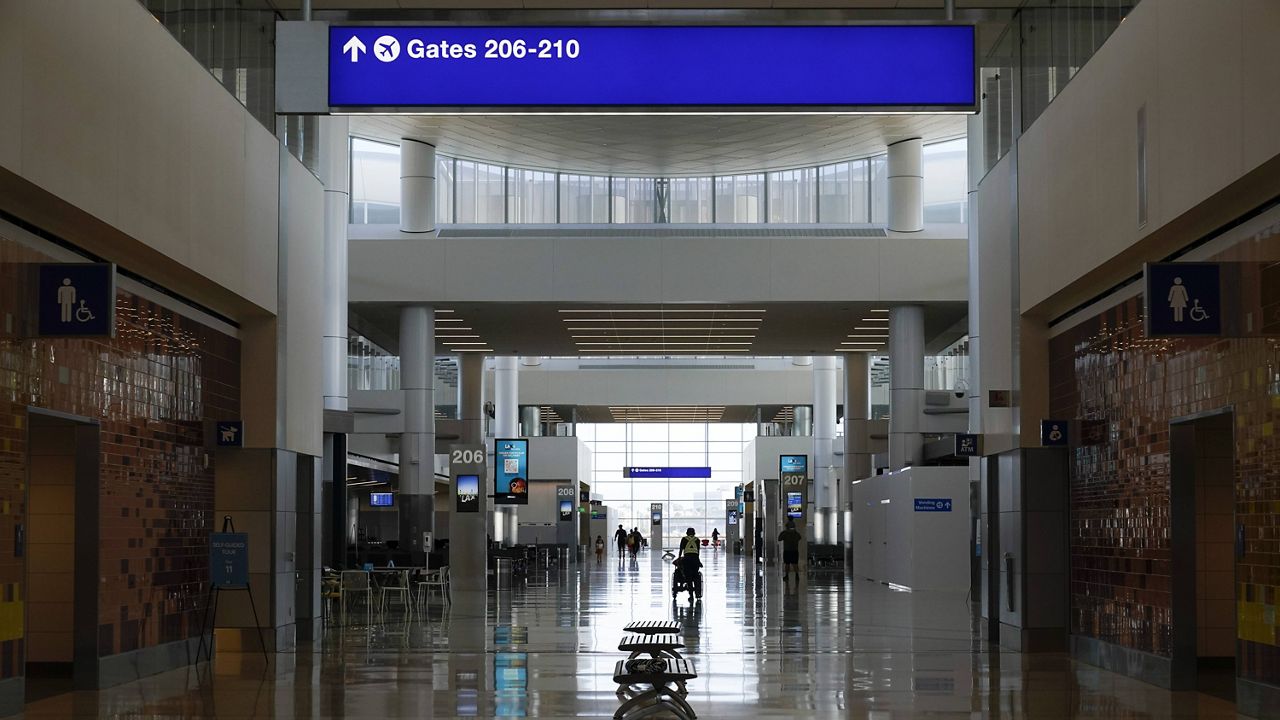 Passengers walk through the new West Gates at Tom Bradley International Terminal at Los Angeles International Airport Monday, May 24, 2021, in Los Angeles. (AP Photo/Ashley Landis)