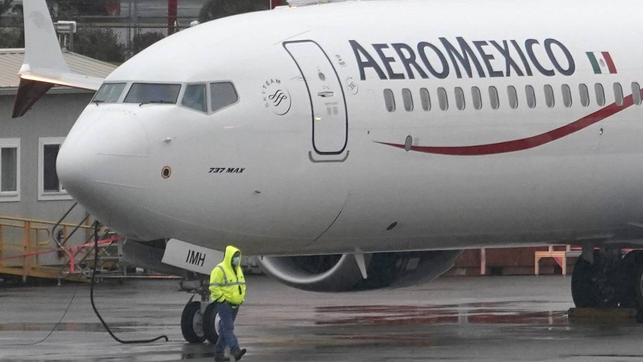 In this Nov. 18, 2020 file photo, a worker wearing a mask walks past a Boeing 737 Max 9 built for Aeromexico as it is prepared for a flight from Renton Municipal Airport, in Renton, Wash. (AP Photo/Ted S. Warren, File)