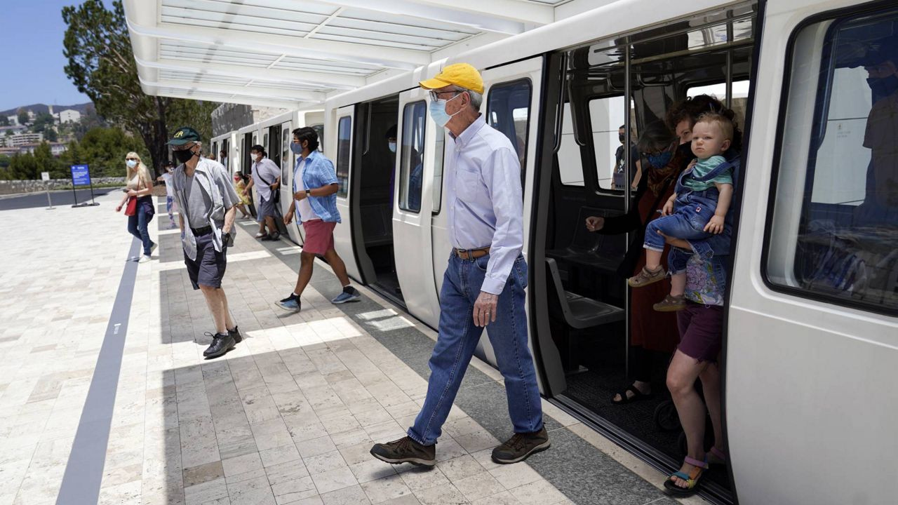 Visitors exit the tram from the parking lot as they arrive at the newly re-opened Getty Center amid the COVID-19 pandemic, May 26, 2021, in Los Angeles. (AP Photo/Marcio Jose Sanchez)