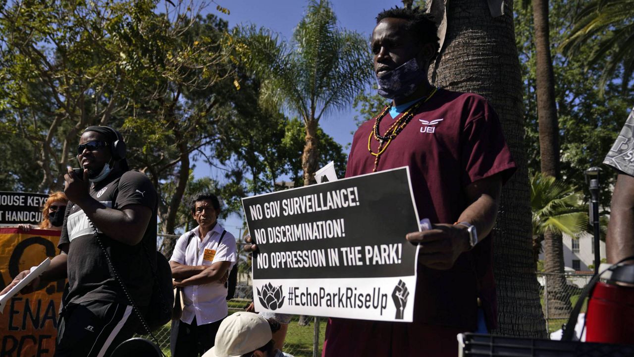 Leonard Averhart, left, speaks during a news conference organized by homeless people and their supporters at the reopened Echo Park, May 26, 2021, in Los Angeles. (AP Photo/Marcio Jose Sanchez)