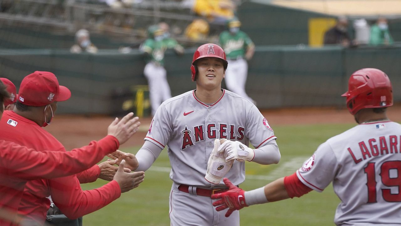 Los Angeles Angels' Shohei Ohtani, center, is congratulated after scoring against the Oakland Athletics during the fifth inning of a baseball game in Oakland, Calif., Saturday, May 29, 2021. (AP Photo/Jeff Chiu)