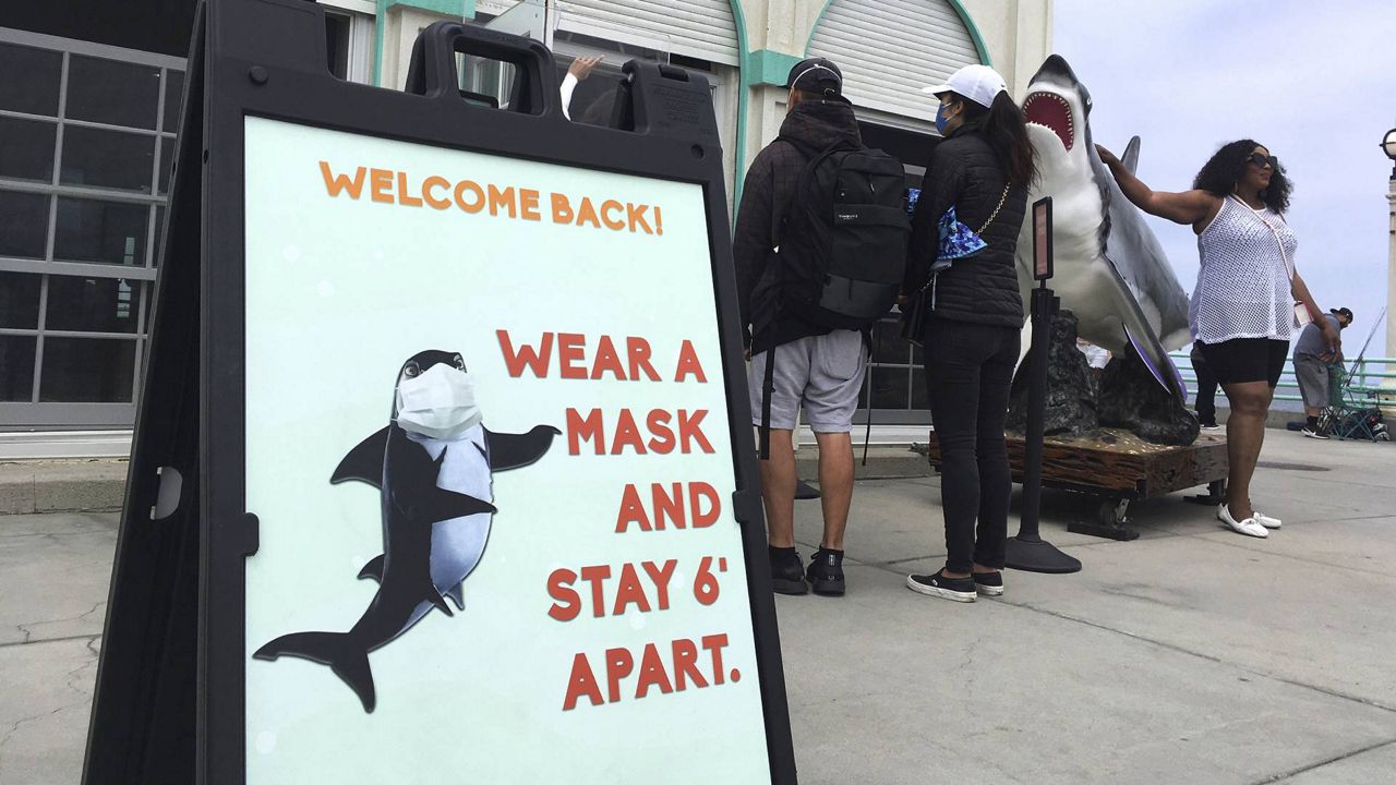 Memorial Day weekend visitors wait to enter the Roundhouse Aquarium on the Manhattan Beach Pier in Manhattan Beach, Calif., May 30, 2021. (AP Photo/John Antczak