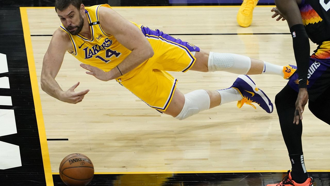 Los Angeles Lakers center Marc Gasol (14) can't save a loose ball as Phoenix Suns center Deandre Ayton (22) looks on during the second half of Game 5 of an NBA basketball first-round playoff series Tuesday in Phoenix. (AP Photo/Matt York)