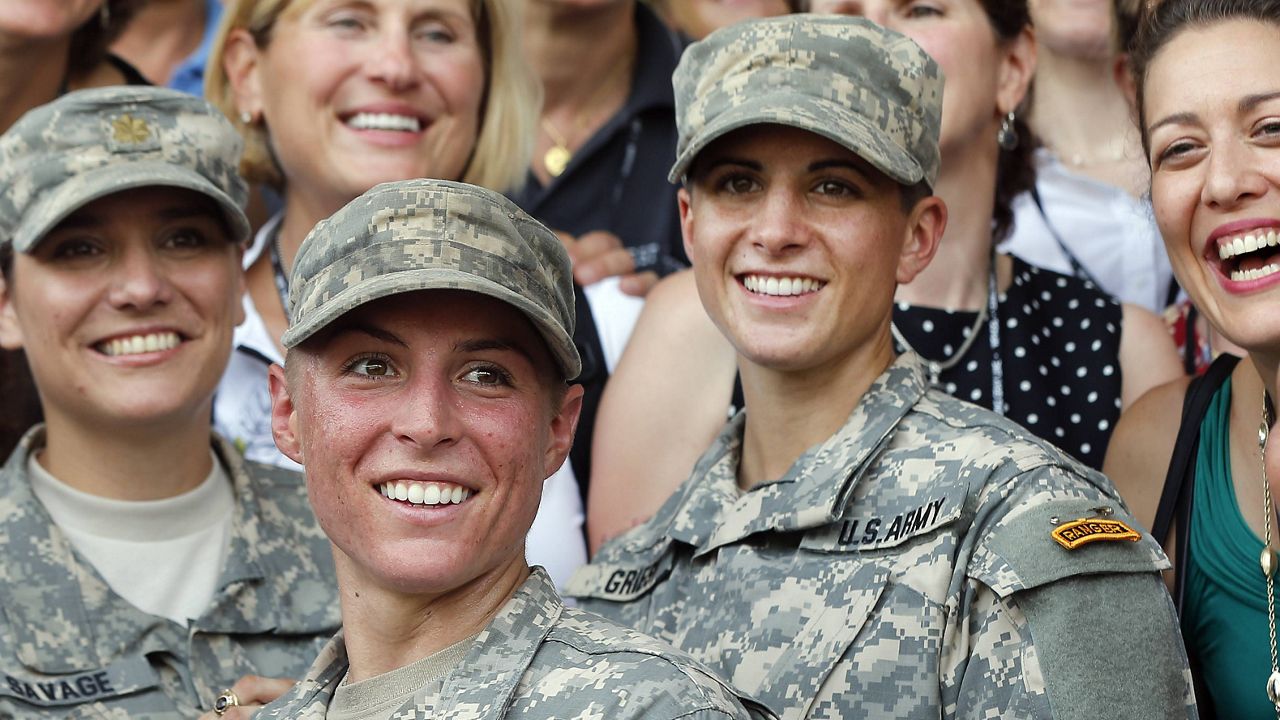 In this Aug. 21, 2015, file photo, Army 1st Lt. Shaye Haver, center, and Capt. Kristen Griest, right, pose for photos with other female West Point alumni after an Army Ranger school graduation ceremony at Fort Benning, Ga. (AP Photo/John Bazemore, File)