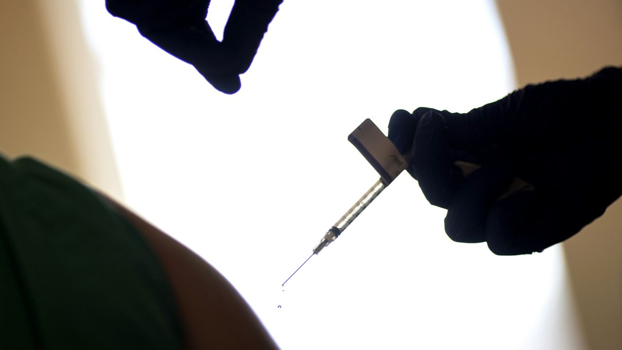 FILE - In this Tuesday, Dec. 15, 2020 file photo, a droplet falls from a syringe after a health care worker was injected with the Pfizer-BioNTech COVID-19 vaccine at a hospital in Providence, R.I. (AP Photo/David Goldman, File)