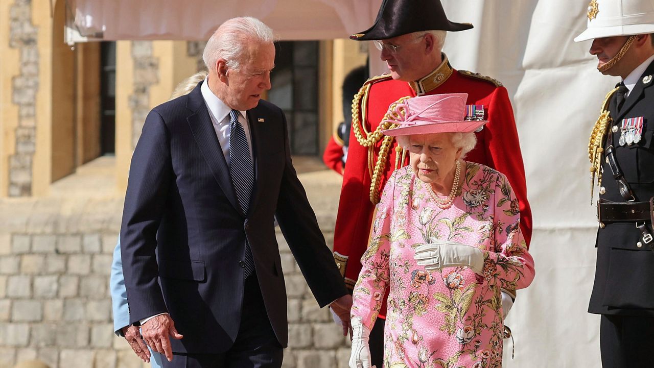 Britain's Queen Elizabeth II, right, walks with U.S. President Joe Biden during his visit to Windsor Castle, near London, Sunday June 13, 2021. (Chris Jackson/Pool Photo via AP)