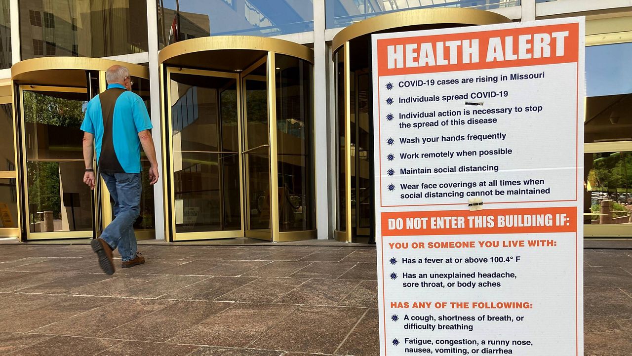 A sign warning of COVID-19 dangers remains in place June 15 outside the a state office building in Jefferson City, Mo. (AP Photo/David A. Lieb)