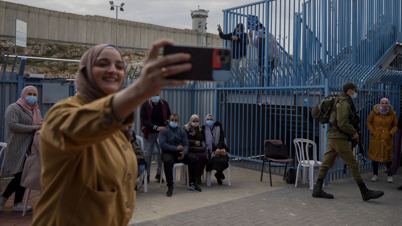 Palestinians take a selfie after receiving the coronavirus vaccine from an Israeli medical team at the Qalandia checkpoint between the West Bank city of Ramallah and Jerusalem on Feb. 23. (AP Photo/Oded Balilty, File)