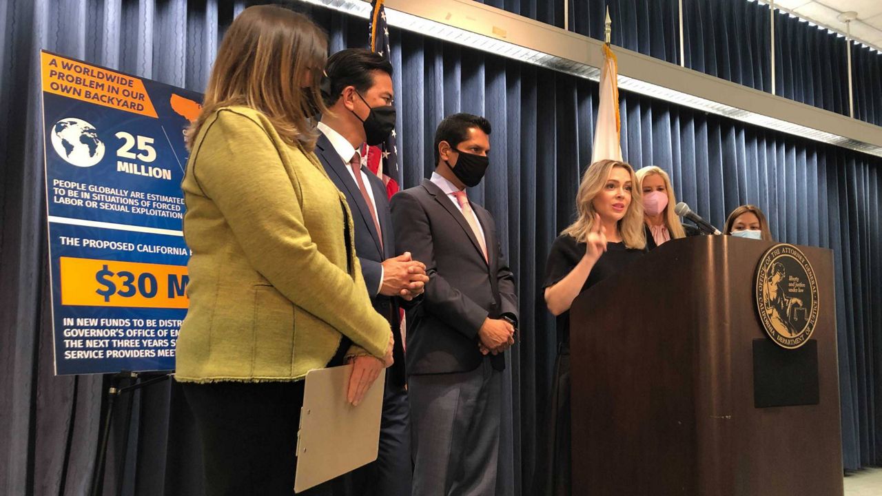 Actress Alyssa Milano at podium and Mira Sorvino, second right, joins activists to discuss new efforts to stop human trafficking in California on Friday, June 18, 2021, in Los Angeles. (AP Photo/Stefanie Dazio)