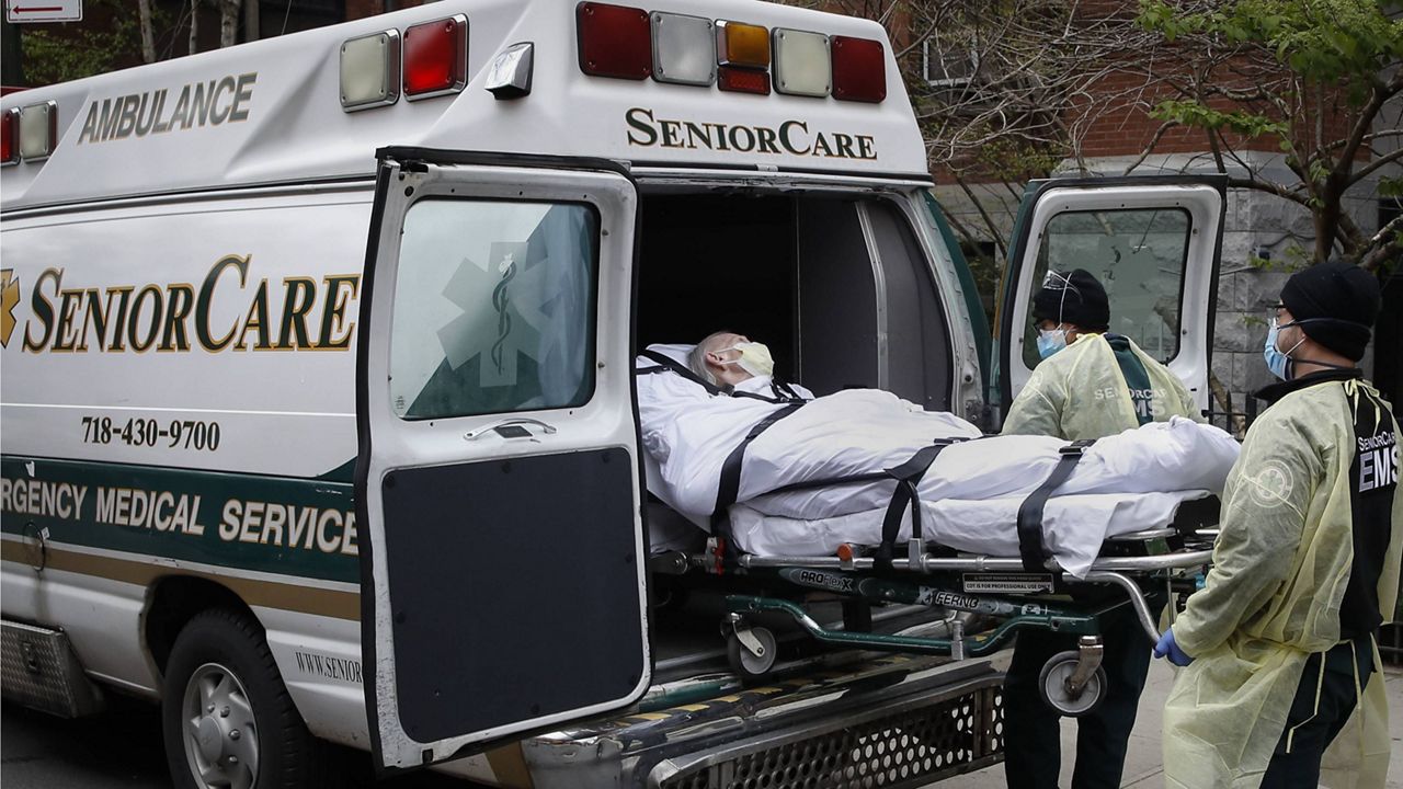 In this April 17, 2020, file photo, a patient is loaded into an ambulance by emergency medical workers outside Cobble Hill Health Center in the Brooklyn borough of New York. (AP Photo/John Minchillo, File)