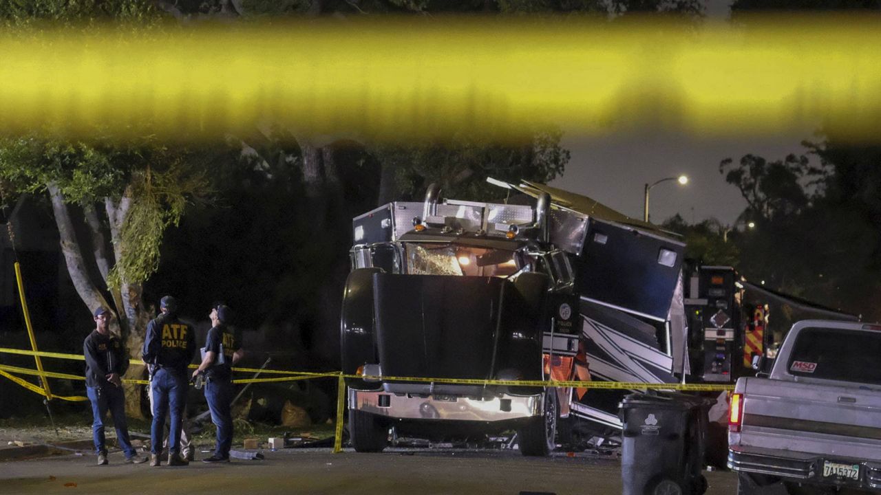 ATF investigators are seen next to the remains of an armored Los Angeles Police Department tractor-trailer after fireworks exploded on June 30, 2021. (AP Photo/Ringo H.W. Chiu)
