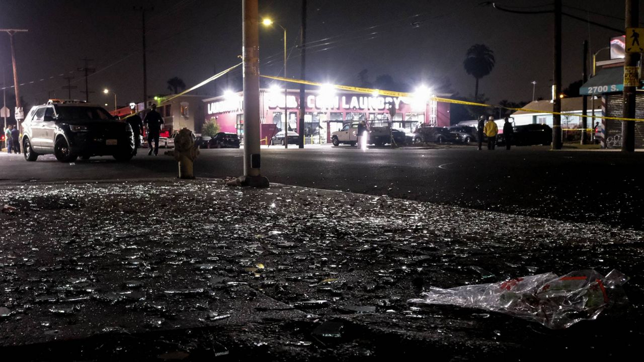 Broken glass sits on a sidewalk and street after a fireworks explosion in Los Angeles on June 30, 2021. (AP Photo/Ringo H.W. Chiu)