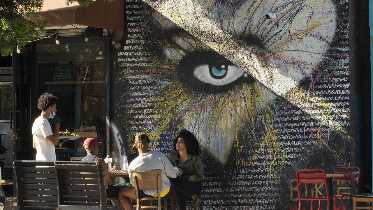 In this June 5, 2021, file photo, people eat outdoors outdoors at a soul food restaurant in Los Angeles. (AP Photo/Damian Dovarganes, File)