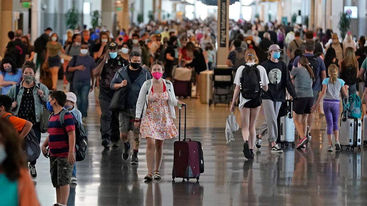 FILE - In this Thursday, July 1, 2021 file photo, people walk through Salt Lake City International Airport in Salt Lake City. (AP Photo/Rick Bowmer, File)