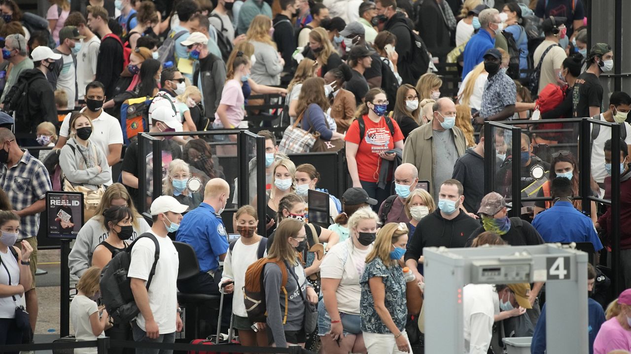 Travelers make their way through a checkpoint at Denver International Airport on Friday. (AP Photo/David Zalubowski)