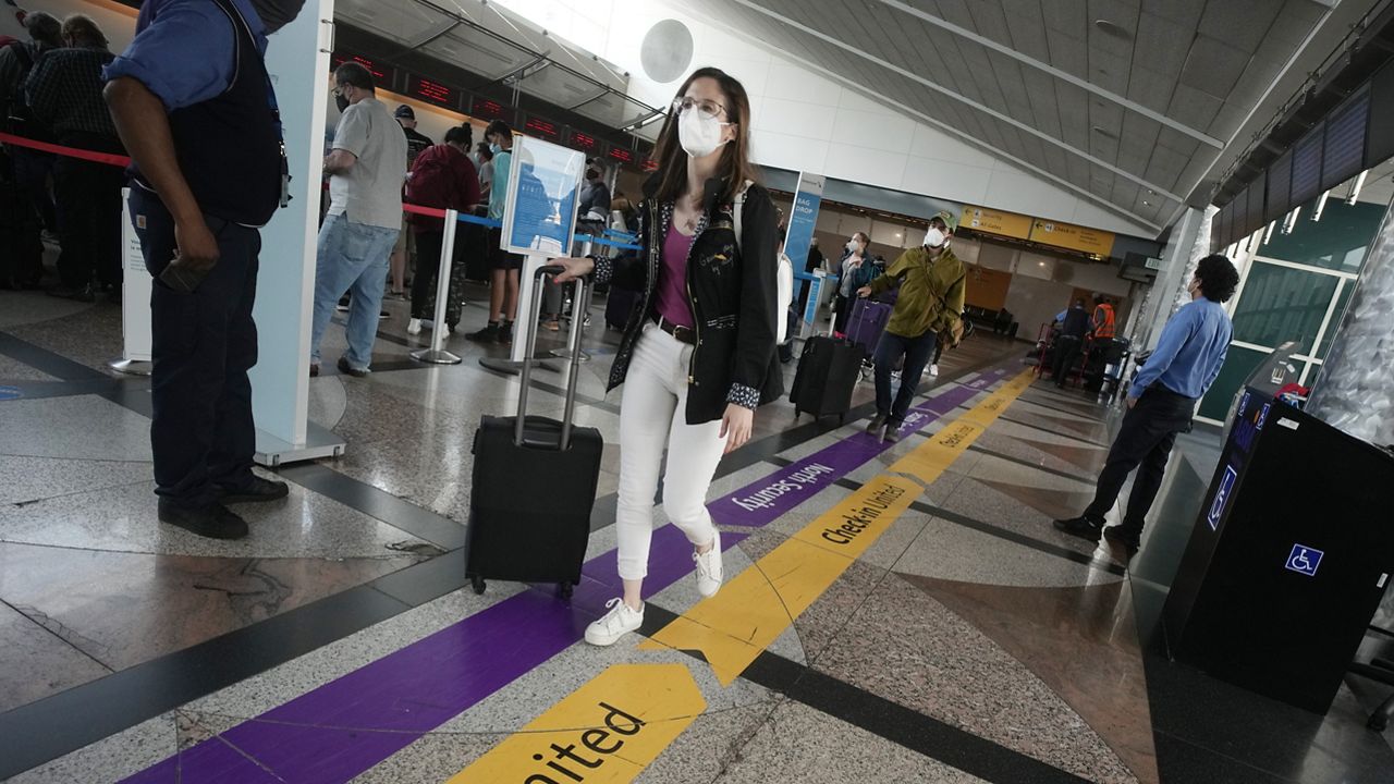 Travelers make their way past the ticketing counters to the south security checkpoint at Denver International Airport Friday, July 2, 2021, in Denver. (AP Photo/David Zalubowski)