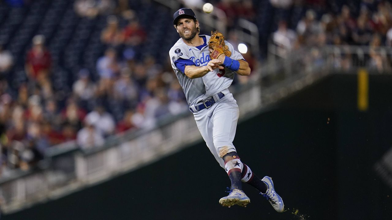 Los Angeles Dodgers second baseman Chris Taylor throws out Washington Nationals' Josh Harrison at first base on a ground out to end a baseball game, Friday, July 2, 2021, in Washington. The Dodgers won 10-5. (AP Photo/Julio Cortez)