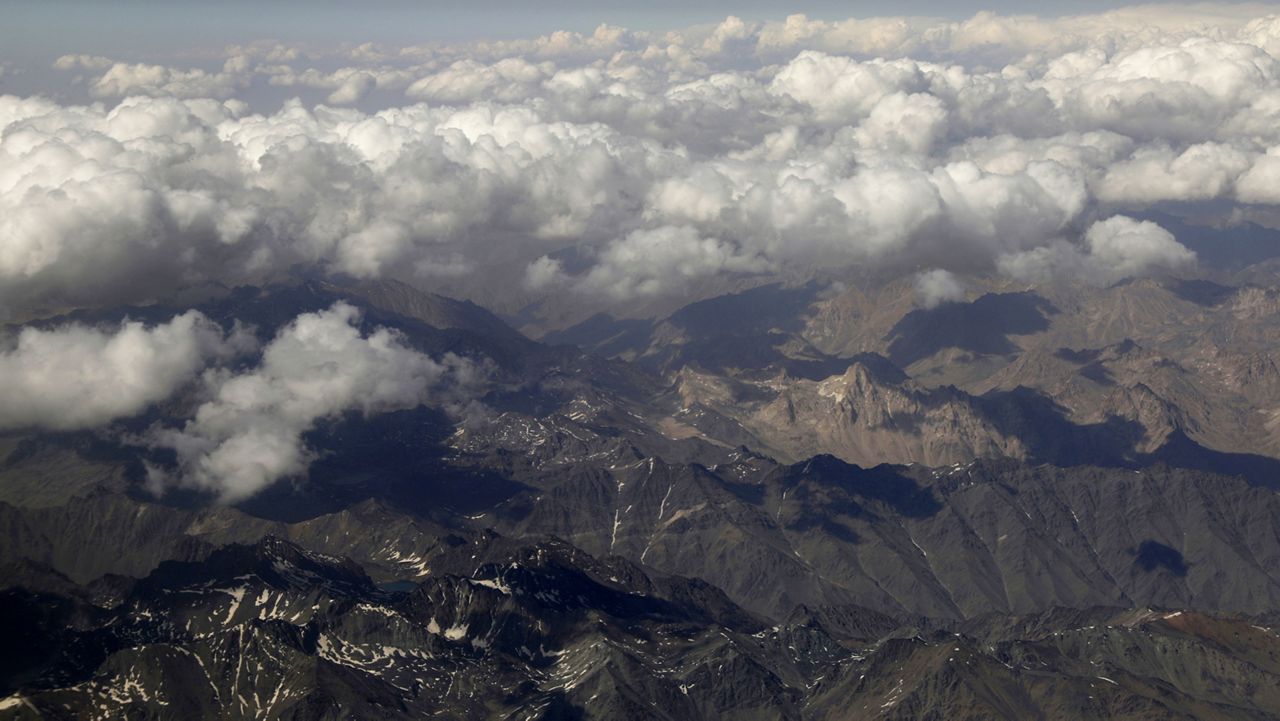 Clouds cover chains of Afghanistan mountains as they are captured through a window of a commercial airplane, Wednesday, July 7, 2021. (AP Photo/Rahmat Gul)