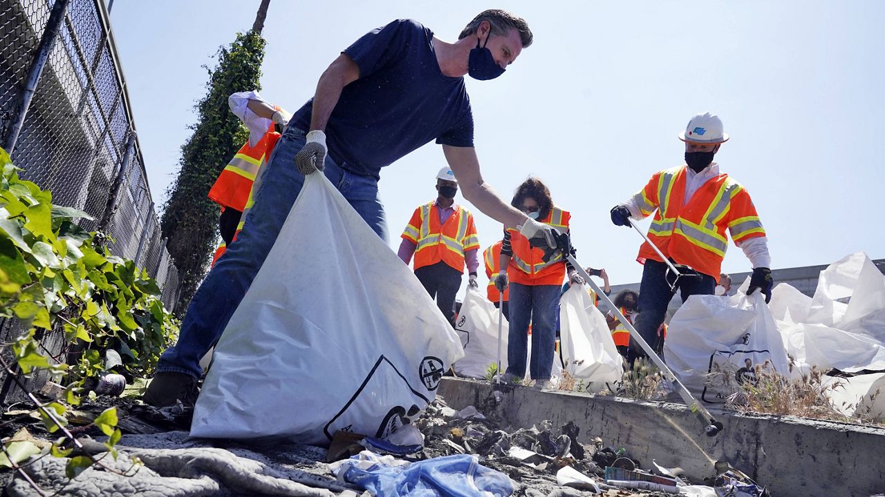 In this May 11, 2021, file photo, California Gov. Gavin Newsom joins a cleanup effort in Los Angeles. (AP Photo/Marcio Jose Sanchez, File)
