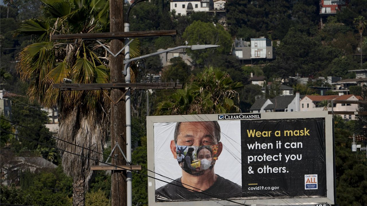 An exterior banner paid for by the State of California encourages residents to wear a mask in the Los Feliz neighborhood of Los Angeles, Wednesday, July 7, 2021. (AP Photo/Damian Dovarganes)