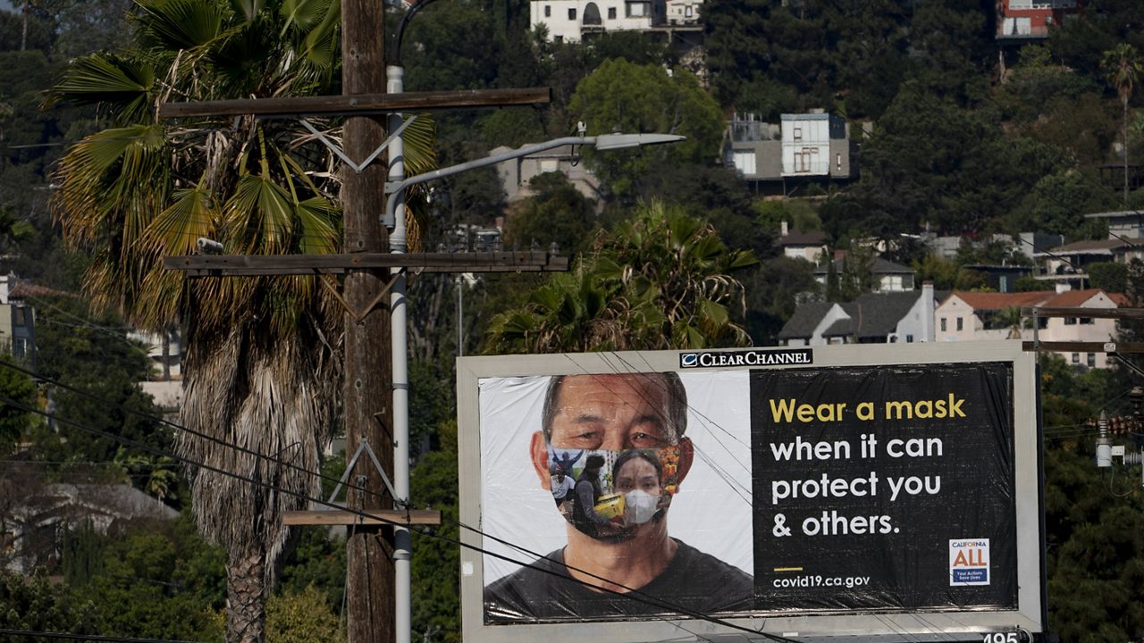 An exterior banner paid for by the State of California encourages residents to wear a mask in the Los Feliz neighborhood of Los Angeles, Wednesday, July 7, 2021. (AP Photo/Damian Dovarganes)