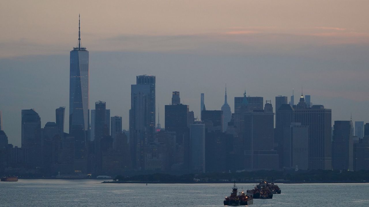 The New York City skyline featuring WTC and other buildings is seen from New York Harbor in New York, Wednesday, June 30, 2021. A few container ships are seen in the water.