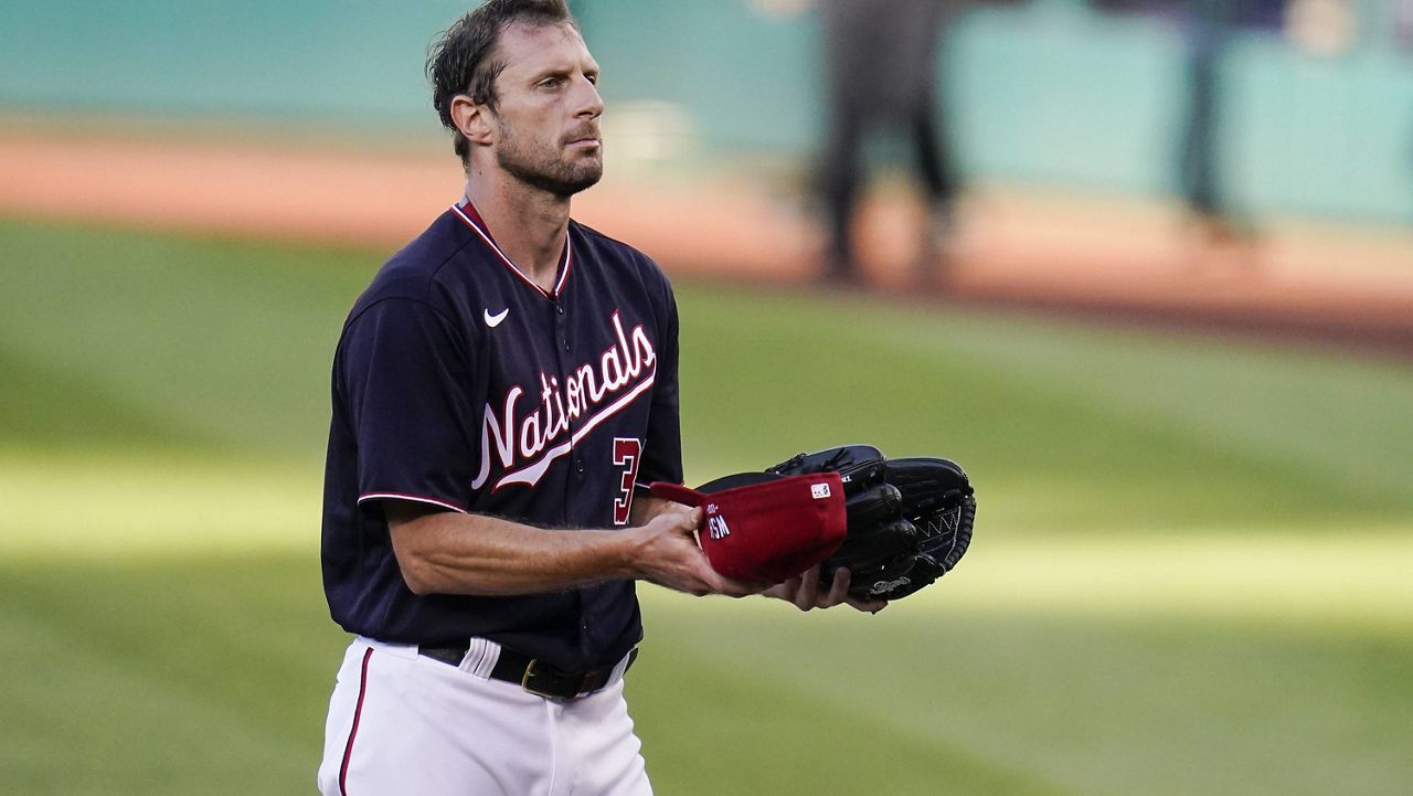 Washington Nationals starting pitcher Max Scherzer presents his gear to be inspected after pitching to the Los Angeles Dodgers during the first inning of a baseball game, Friday, July 2, 2021, in Washington. (AP Photo/Julio Cortez)