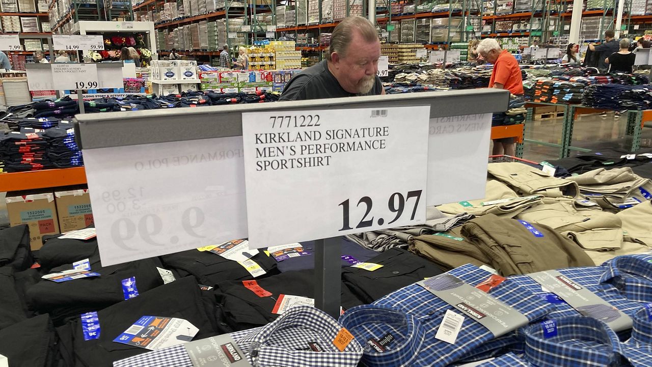 A sign displays the price for shirts as a shopper peruses the offerings at a Costco warehouse in Lone Tree, Colo. (AP Photo/David Zalubowski)