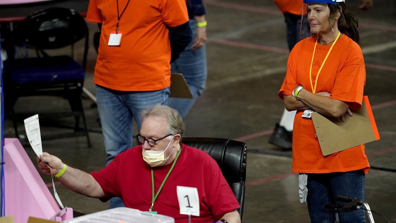 FILE - In this May 6, 2021, file photo, Maricopa County ballots cast in the 2020 general election are examined and recounted by contractors working for Florida-based company, Cyber Ninjas at Veterans Memorial Coliseum in Phoenix. (AP Photo/Matt York, Pool, File)