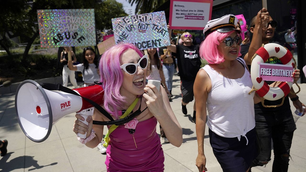 Britney Spears supporters Melanie Mandarano, left, of New York and Kiki Norberto of Phoenix, Ariz., lead a march around the Stanley Mosk Courthouse, where a hearing concerning the pop singer's conservatorship was taking place, Wednesday, July 14, 2021, in Los Angeles. (AP Photo/Chris Pizzello)