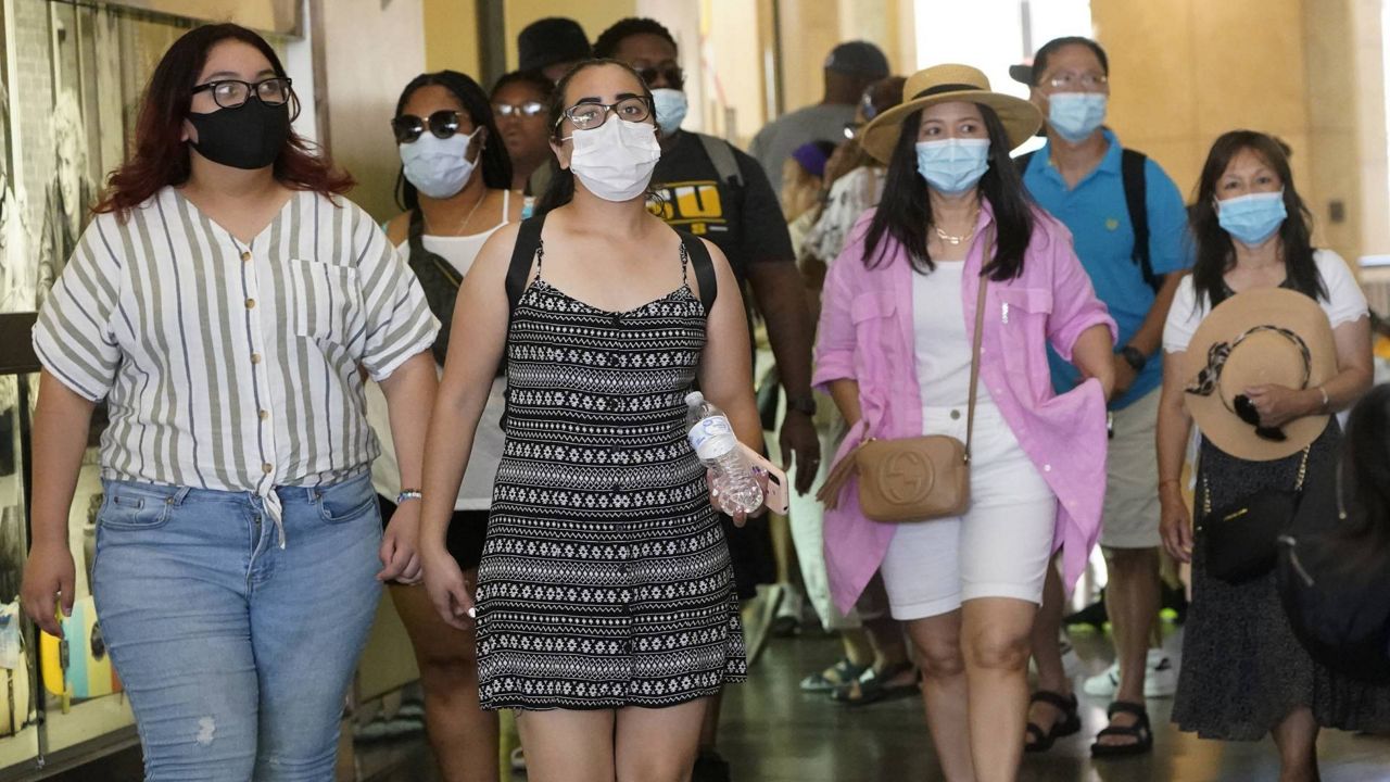 Visitors wear masks as they walk in a shopping district in the Hollywood section of Los Angeles on July 1, 2021. (AP Photo/Marcio Jose Sanchez)