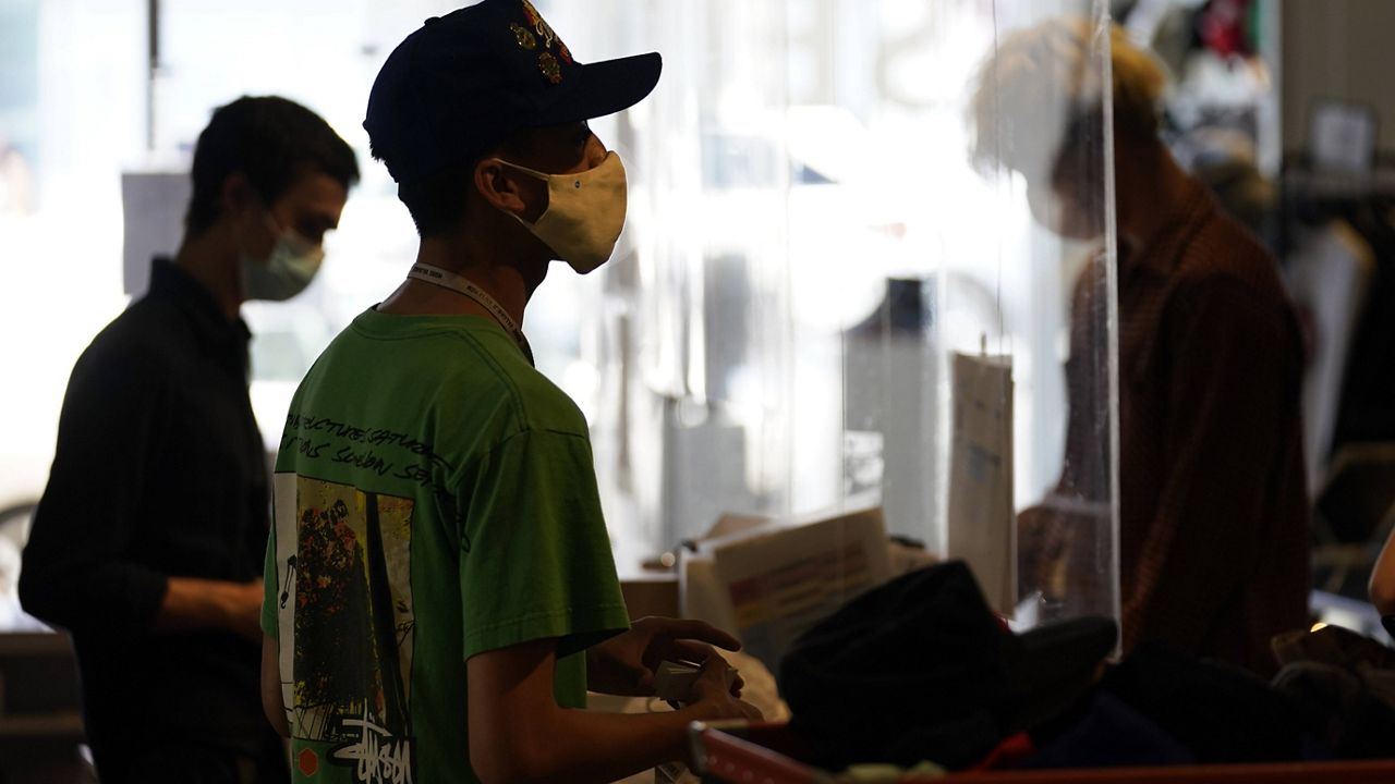 Employees check out customers at 2nd Street second hand store Monday, July 19, 2021, in the Fairfax district of Los Angeles. (AP Photo/Marcio Jose Sanchez)