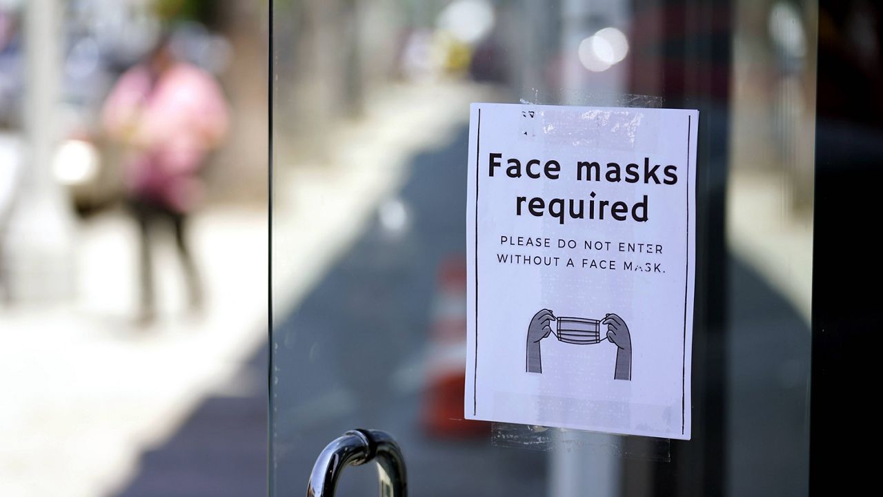 A sign advises shoppers to wear masks outside of a store Monday, July 19, 2021, in the Fairfax district of Los Angeles. (AP Photo/Marcio Jose Sanchez, File)