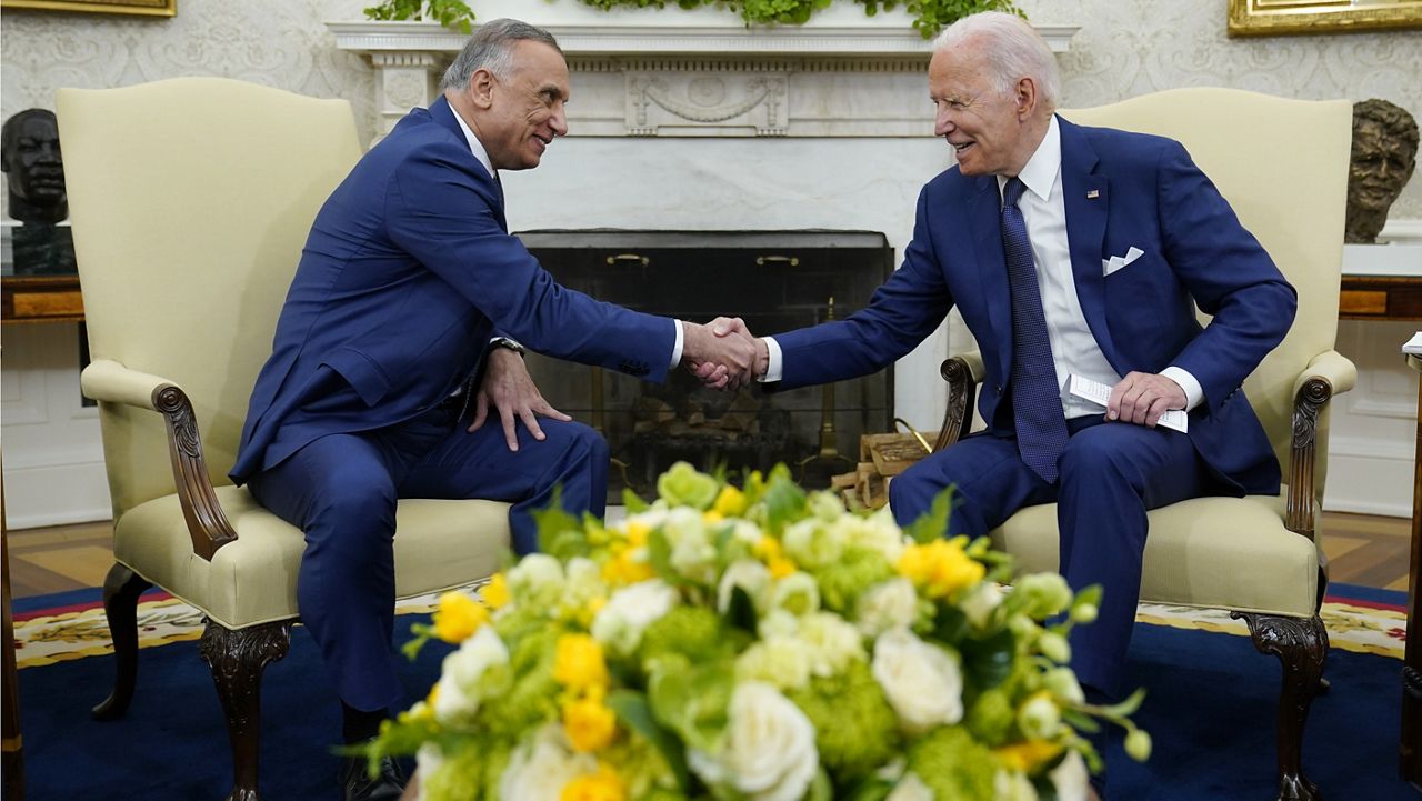President Joe Biden, right, shakes hands with Iraqi Prime Minister Mustafa al-Kadhimi, left, during their meeting in the Oval Office of the White House in Washington, Monday, July 26, 2021. (AP Photo/Susan Walsh)