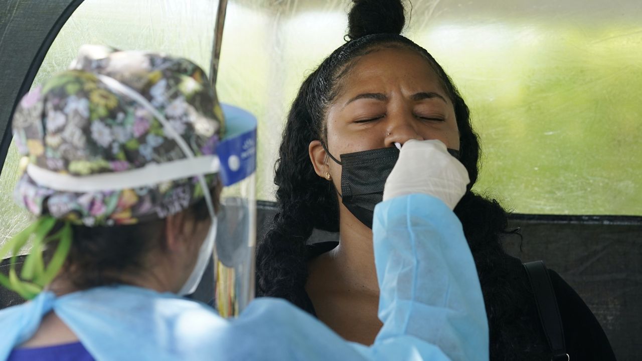 Chantel Powell gets a COVID-19 PCR test in order to travel later this week at a Miami-Dade County testing site, Monday, July 26, 2021, in Miami. More than 73,000 new coronavirus cases were reported in Florida over the previous week, according to the state health department, nearly seven times the 12,000 reported a month ago. (AP Photo/Marta Lavandier)