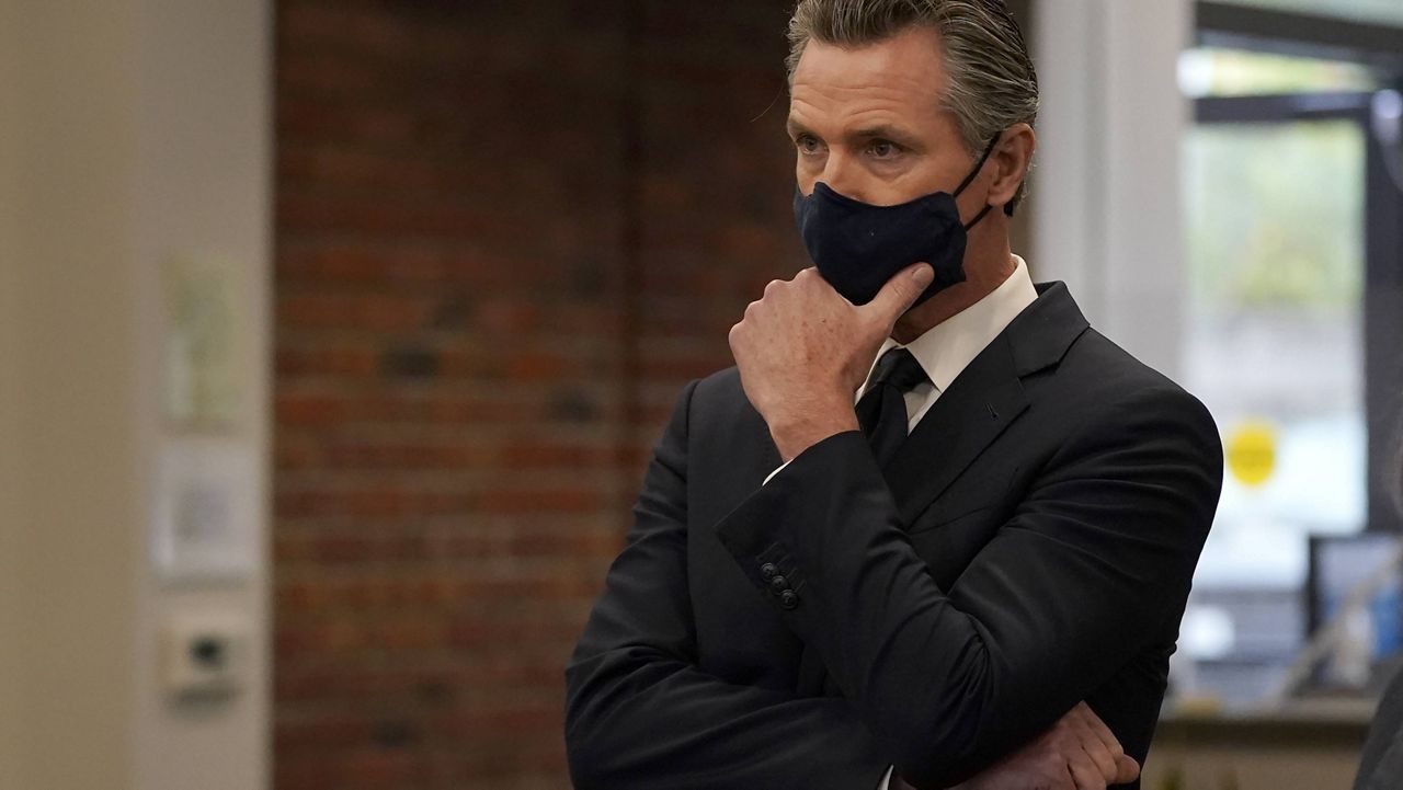 Gov. Gavin Newsom listens to speakers at a news conference in Oakland, Calif., Monday, July 26, 2021. (AP Photo/Jeff Chiu)